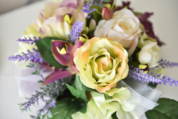 Bright assorted-colored artificial flowers in a vase