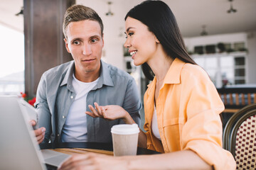 Couple drinking coffee and having discussion using laptop