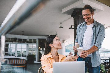Ethnic female freelancer having coffee break with male companion