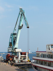 Large cranes for loading goods on large marine cargo ships at the container terminal in the port of Odessa sea port on a foggy day
