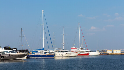Fototapeta premium Sailboat harbor, many beautiful moored sail yachts in the sea port, modern water transport, summertime vacation, luxury lifestyle and wealth concept