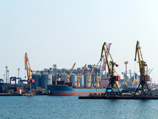 Large cranes for loading goods on large marine cargo ships at the container terminal in the port of...