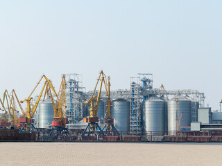 Large cranes for loading goods on large marine cargo ships at the container terminal in the port of Odessa sea port on a foggy day