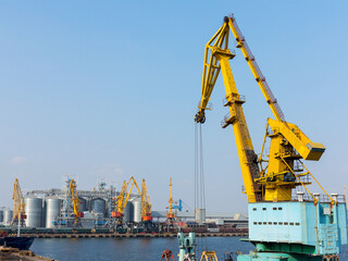 Large cranes for loading goods on large marine cargo ships at the container terminal in the port of Odessa sea port on a foggy day