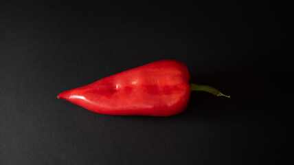 Fresh red pepper on a black background.