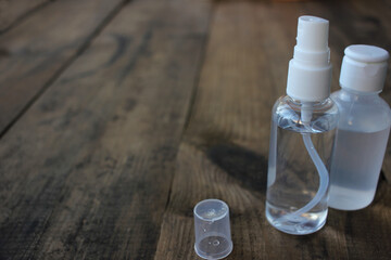 Hand sanitizer spray bottle on wooden table background with copy space. Pandemic protective supply.	