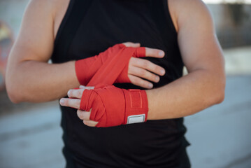 Closeup male hand of boxer with red boxing bandages.