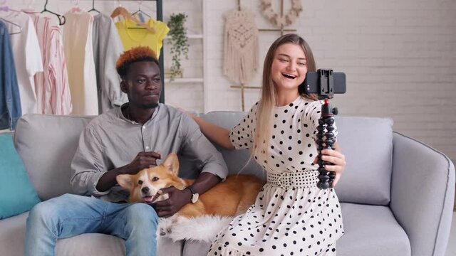 A Girl and Boy Takes Pictures of Themselves, Conducts a Blogging. A Man Stroking a Cute Dog While Shooting Videoblog. Making Video Broadcast for Subscribers at Home About Pets.