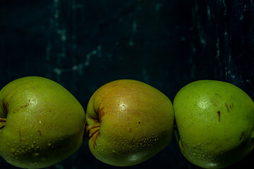 Fototapeta na wymiar apples in a transparent vase on a blue background, one apple, three apples, fresh apples, red apple, green apple, yellow apple, bitten apple