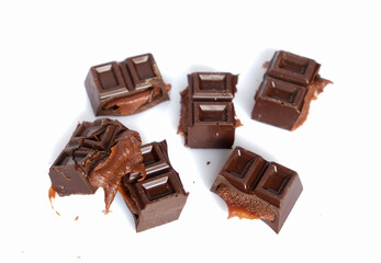 sweet products in pieces and in packaging, dark chocolate with filling on a white background, milk chocolate