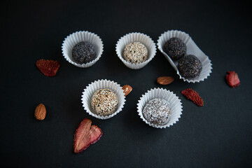 Top view of set handmade fruit and chocolate candies on a black background