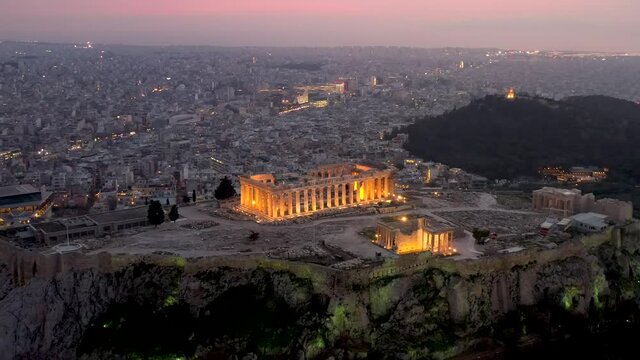 Der Parthenon Tempel auf der Akropolis in Athen, Griechenland, umgeben von der Altstadt Plaka bis zum Meer nach Pir&auml;us mit Lichtern am Abend