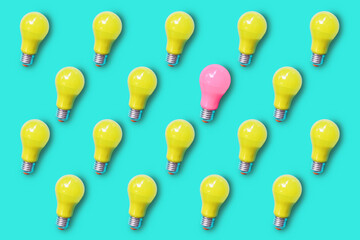 Pattern of yellow lightbulb on green turquoise background with only one lightbulb in pink color ,...
