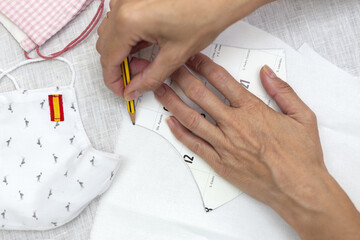 Woman's hands cutting face masks on for protection