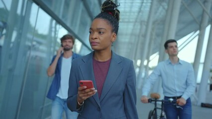 African american attractive business woman smart casual style using smartphone communicating walking arriving to the city. Airport exterior. Business people. Outdoors. - Powered by Adobe