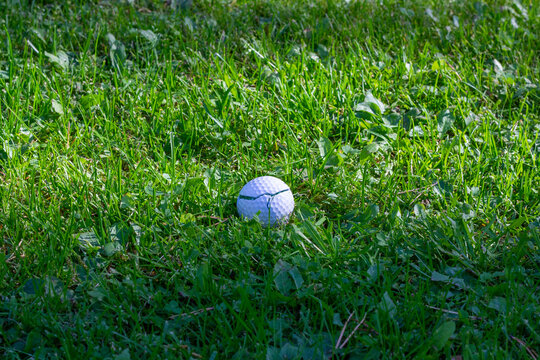 A broken golf ball in green grass.