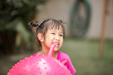 A blurred background view of an Asian girl playing with her family during vacation, learning outside the classroom from real experiences.