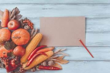Naklejka na ściany i meble Autumn background, fallen leaves, fruits, vegetables on rustic wooden table. Seasonal corner set, aged vintage paper, copy space. Thanksgiving food, healthy and fresh, top view, flat lay.