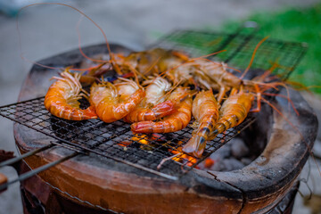 Close-up view of the seafood grill with charcoal stove (shrimp, squid, shellfish) gives it a delicious aroma, eaten with a delicious dipping sauce.