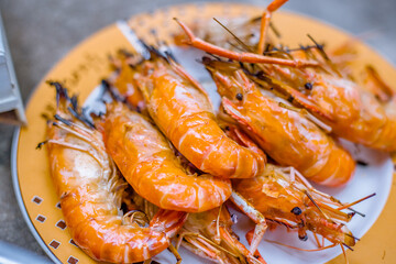 Close-up view of the seafood grill with charcoal stove (shrimp, squid, shellfish) gives it a delicious aroma, eaten with a delicious dipping sauce.