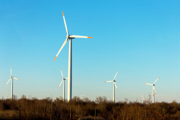 Wind Turbines at Dusk. Landscape sunset with windmills. Renewal source of electricity. Wind turbines field new technology for clean energy on mountain, sunset view with colorful twilight on sky