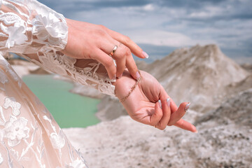 Hands of the bride on the background of blue quarries