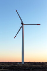 Wind Turbines at Dusk. Landscape sunset with windmills. Renewal source of electricity. Wind turbines field new technology for clean energy on mountain, sunset view with colorful twilight on sky