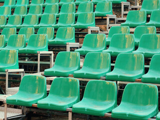 Fototapeta premium Amphitheater dark green seats abstract background. Places in the stands of the stadium