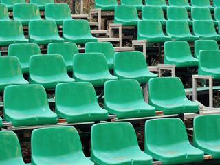 Fototapeta premium Amphitheater dark green seats abstract background. Places in the stands of the stadium