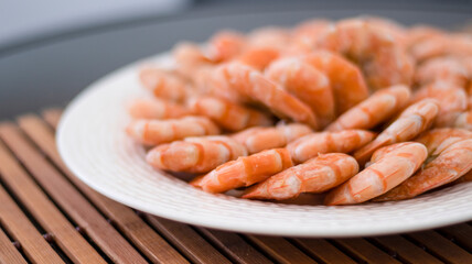 Tiger prawns on a large white plate, blurred background. Seafood.