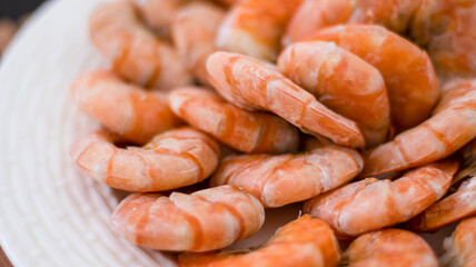 Tiger prawns on a large white plate, blurred background. Seafood.