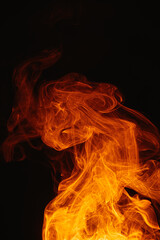 Fototapeta premium Orange smoke on a dark background. Intricate swirls of colored smoke. An abstract imitation of night flames.
