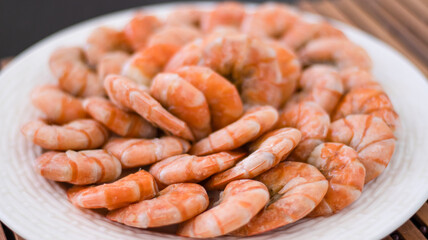 Tiger prawns on a large white plate, blurred background. Seafood.