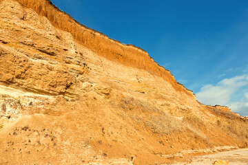 Fototapeta premium Rockslide. Mountain landslide in an environmentally hazardous area. Large cracks in earth, descent of large layers of earth blocking road. Mortal danger of dam at foot of landslide slopes of mountain