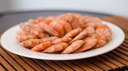 Tiger prawns on a large white plate, blurred background. Seafood.