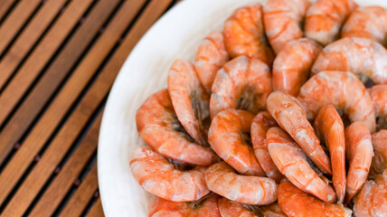 Tiger prawns on a large white plate, blurred background. Seafood.