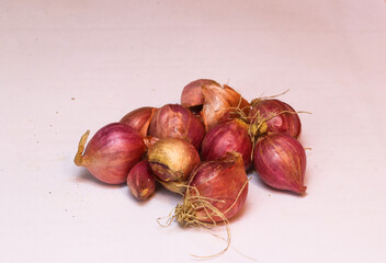 Allium cepa, many red colour fresh onion in the shop with onion background. The onion, also known as the bulb onion or common onion, is a vegetable that is the most widely cultivated species of the ge