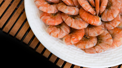 Tiger prawns on a large white plate, blurred background. Seafood.