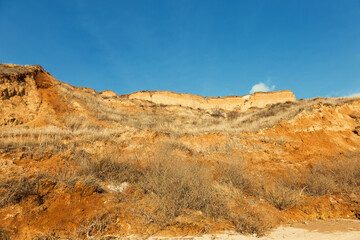Rockslide. Mountain landslide in an environmentally hazardous area. Large cracks in earth, descent of large layers of earth blocking road. Mortal danger of dam at foot of landslide slopes of mountain