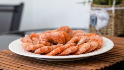 Tiger prawns on a large white plate, blurred background. Seafood.