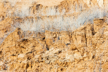 Background of mountain landslide in an environmentally hazardous area. Large cracks in the ground, the descent of soil layers, coquina. Deadly risk of coastal collapse