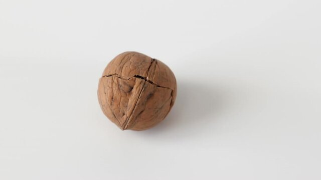 cracked walnut rotating on white background close-up. concept of vegetarian food