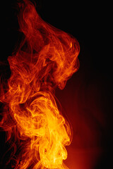 Fototapeta premium Orange smoke on a dark background. Intricate swirls of colored smoke. An abstract imitation of night flames.