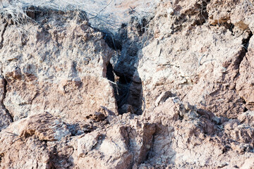 Background of mountain landslide in an environmentally hazardous area. Large cracks in the ground, the descent of soil layers, coquina. Deadly risk of coastal collapse