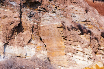 Background of mountain landslide in an environmentally hazardous area. Large cracks in the ground, the descent of soil layers, coquina. Deadly risk of coastal collapse