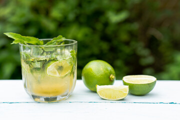 A glass of lemonade or a Mojito cocktail with lime and mint, a cold refreshing drink or a drink with ice. Summer concept. Cold detox water, copy space
