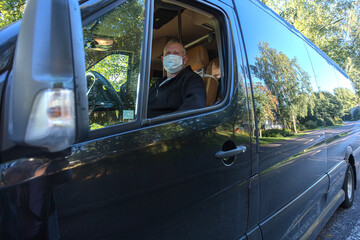 The driver in the medical mask is driving the bus
Safe driving during a pandemic, protection against coronavirus