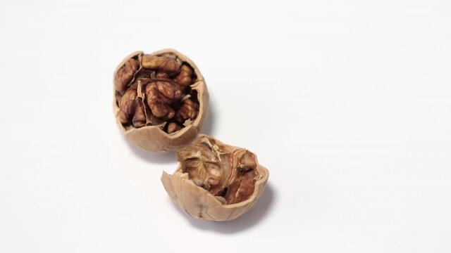 cracked on two half walnut rotating on white background close-up
