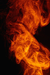 Fototapeta premium Orange smoke on a dark background. Intricate swirls of colored smoke. An abstract imitation of night flames.
