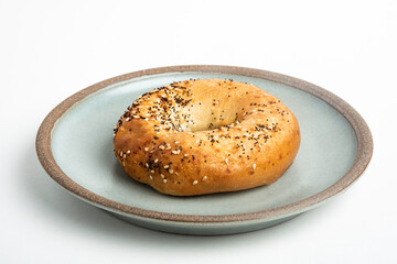 A Freshly Baked Single Bagel On A Ceramic Plate
